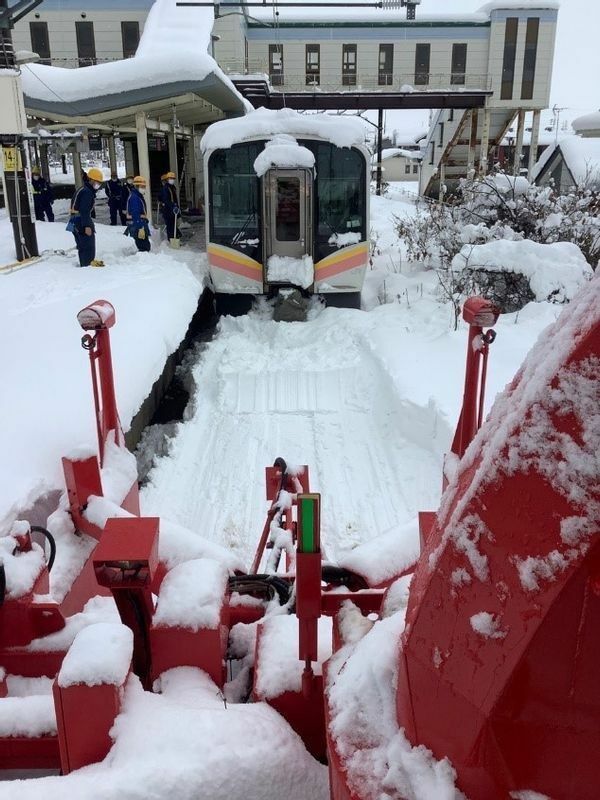 雪に埋まってしまった電車を人海戦術で掘り起こし、除雪用車両が到着。（JR新潟支社のプレスリリース資料より）