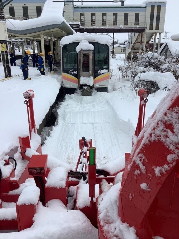 雪に埋まってしまった電車を人海戦術で掘り起こし、除雪用車両が到着。(JR新潟支社のプレスリリース資料より)