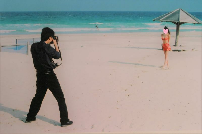 こちらは仕事中の高津さん。「海辺でのコスプレーヤー水着撮影風景」です。（本人提供）