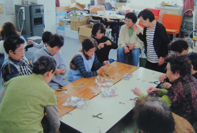 東日本大震災の被災者にワイヤーアートを指導する
