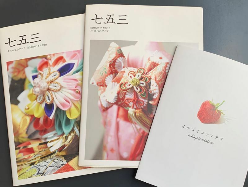 JOJI WAKITAさんによる非売品の写真集（左の2冊）。後にパンフレット（右端）を団体独自で制作、イチゴイニシアチブの活動の周知につながった（筆者撮影）