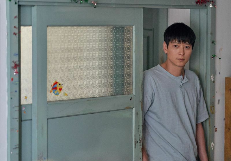 映画『ベイビー・ブローカー』より、児童養護施設出身のドンス（カン・ドンウォン）。背中で悲哀を伝える演技が印象に残る