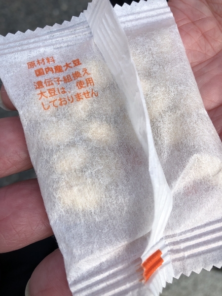 京都府内のある神社で配られた「福豆」。遺伝子組み換え大豆を使用していない旨の表示はあるが、乳幼児の誤嚥に関する情報は記載されていない。