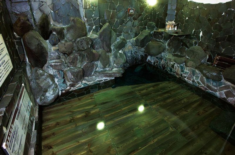 武田信玄が愛した岩風呂。湯治客は浴場にある神棚に手を合わせてから温泉に入る（写真提供・源泉館）