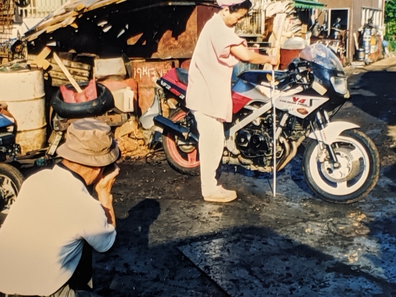 亡くなった息子のバイクを保管していた遺族と、そのバイクの損傷箇所を検証する鑑定人の駒沢幹也氏（筆者撮影）