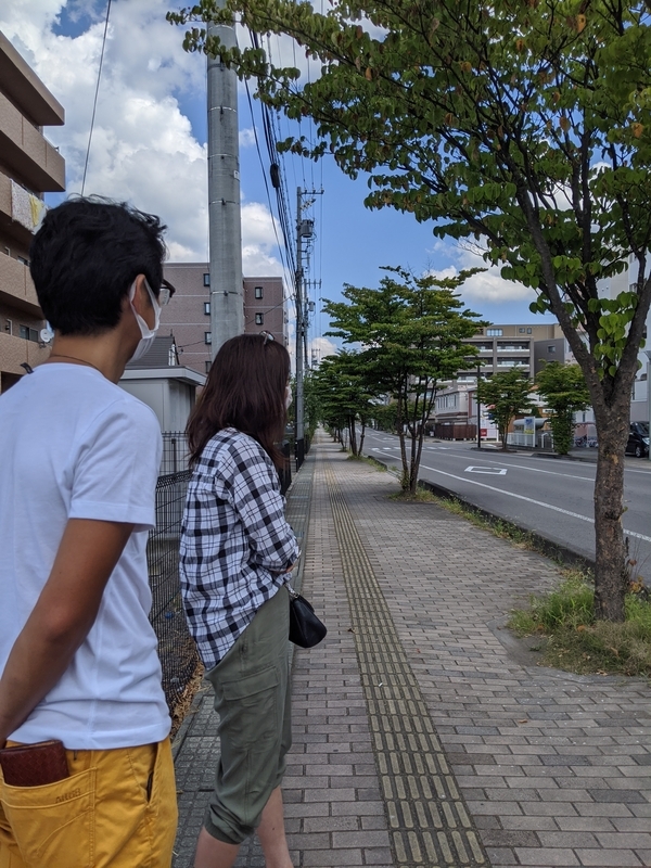 事故から5年目の夏、樹生さんが飛ばされ倒れていた場所から、衝突地点の横断歩道を見つめる和田さん夫妻（筆者撮影）