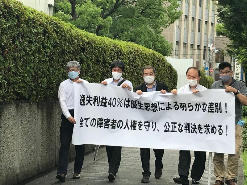 大阪地裁の前でデモを行う聴覚障害者団体の代表者らと井出さん（左から2人目）　　（井出さん提供）