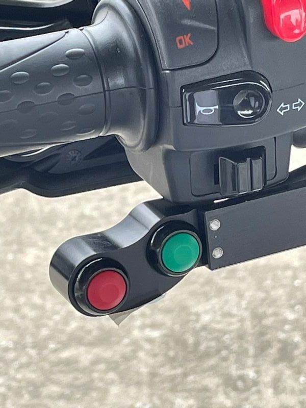 ギアチェンジはハンドルにつけられたスイッチを指で操作して行う。緑のボタンはシフトアップ、赤はシフトダウンだ（筆者撮影）