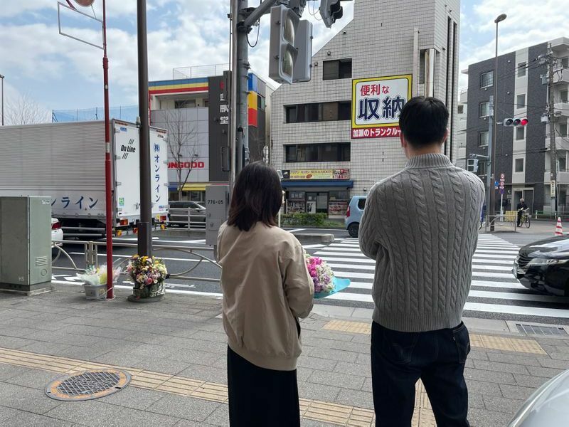 耀子さんが命を奪われた横断歩道を見つめる波多野さん夫妻（筆者撮影）