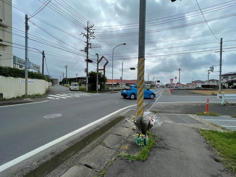 事故現場の交差点。加害者は写真手前から右折し、対向のバイクと衝突した。誰からも好かれていたという陽輔さん。事故現場には花や飲み物、お菓子等が絶えることがない（筆者撮影）