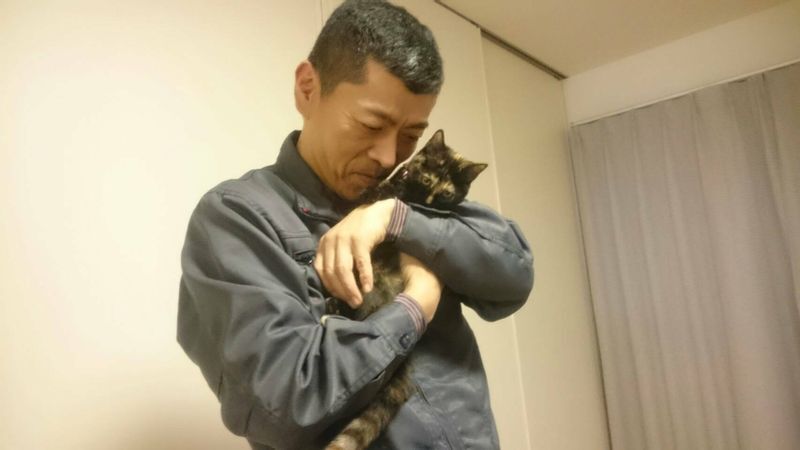 飼い猫を抱く被害者の小柳憲さん。とても優しい性格だったという(遺族提供)
