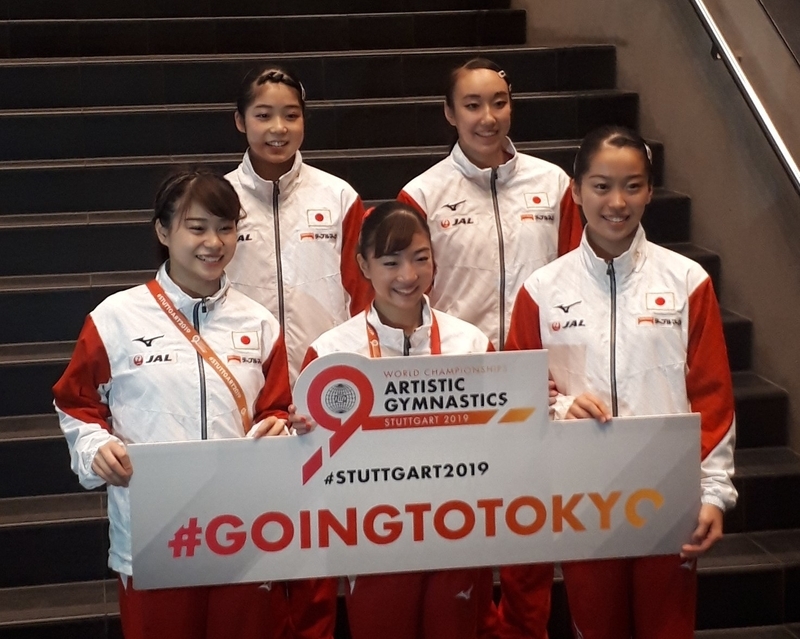 東京五輪出場権を勝ち取ったチームや選手の記念撮影用に用意されているボードを手に笑顔を浮かべる日本女子チーム（撮影：矢内由美子）