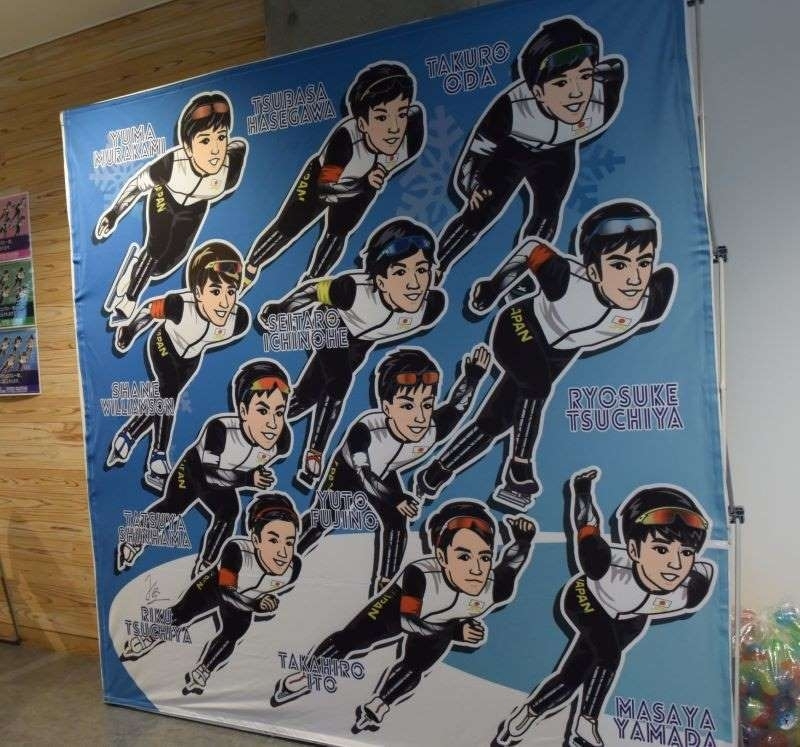 スケート会場では選手のイラストのグッズ販売もある。新濱選手、村上選手はこの絵のどこにいる？（撮影：矢内由美子）