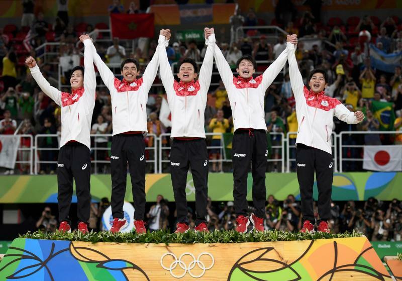 2016年リオデジャネイロ五輪団体金メダルの表彰式で歓びを爆発させ、ジャンプする日本チーム。右から山室さん、内村航平さん、田中佑典、白井健三さん、加藤凌平