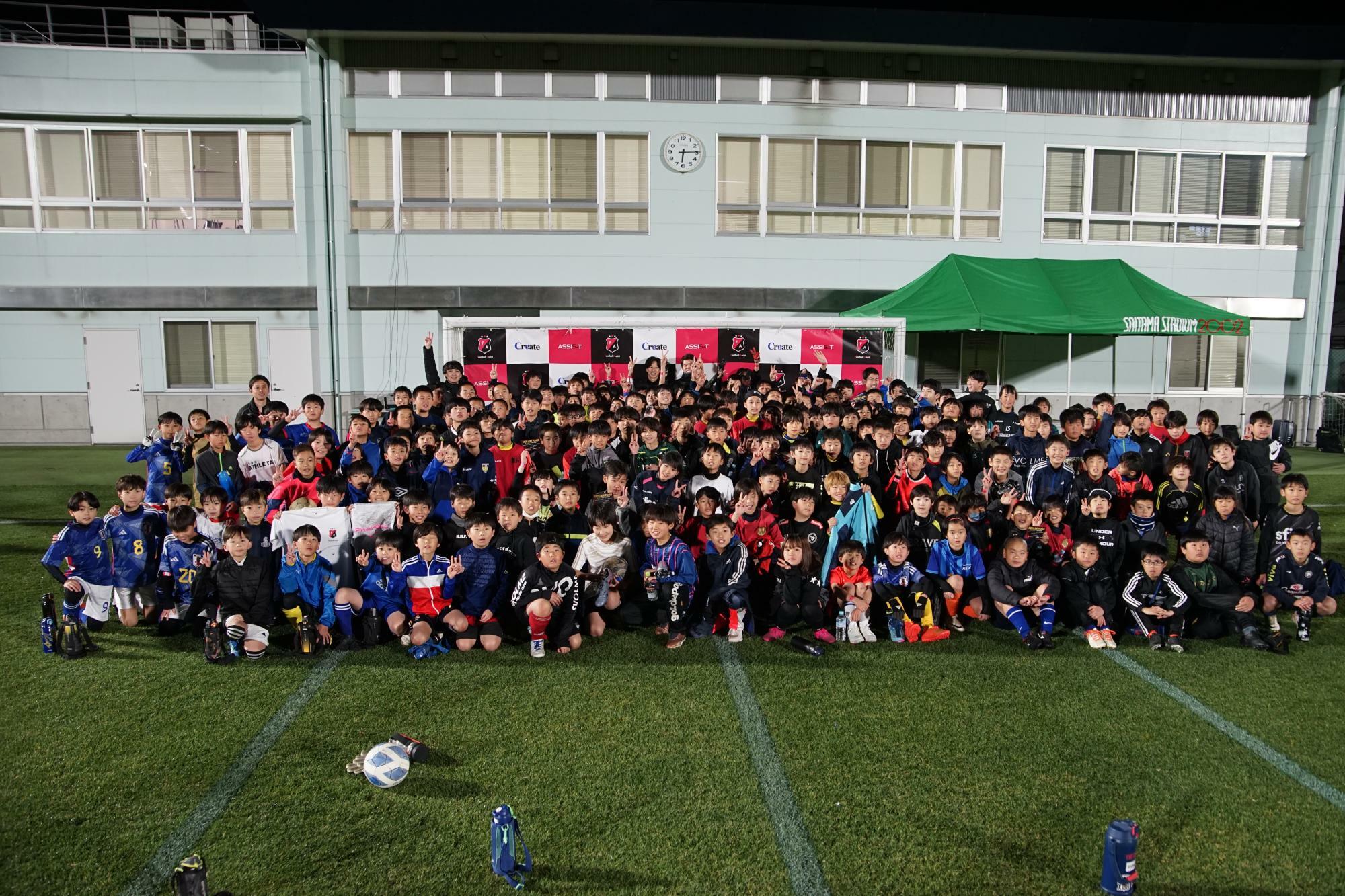 12月26日、埼玉スタジアム第2グラウンドで開催したサッカークリニックには450人の小学生が参加。高学年の部の子どもたちと記念撮影（写真提供：FootballAssist)