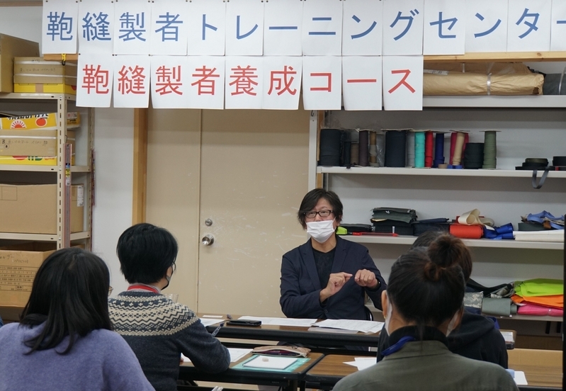鞄縫製者を育成するコースでは兵庫県鞄工業組合理事長で鞄メーカー「由利」の由利昇三郎社長（中央）も講義し、鞄づくりの基本を教える（筆者撮影）