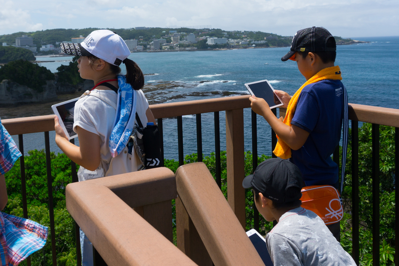 貸し出されたiPadを使い、展望台からの眺めを撮影する子どもたち（筆者撮影）