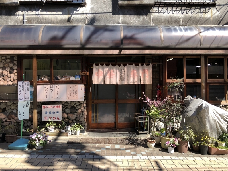 「玉屋」(東十条)の存在感ある外観。モルタル仕上げの外壁と古びた暖簾が昭和の風景を今に遺す。