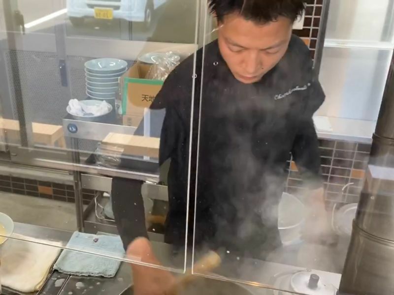 一人一人のお客さんに心を込めて麺上げをする、三代目店主の品川徳孝さん。