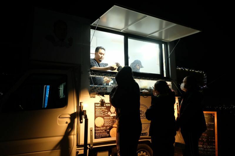 1月の夜、仕事帰りのインドネシア人たちが寒風を突いてやって来た＝米元文秋写す