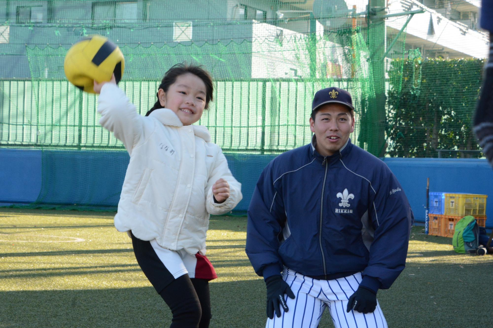 立教大学野球部グラウンドでボール投げをする子どもと野球部員