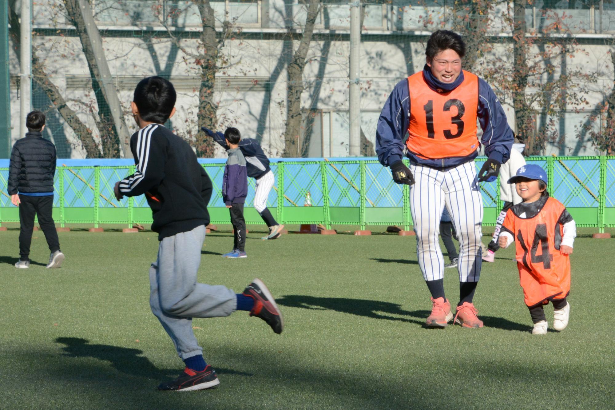 立教大学野球部グラウンドで鬼ごっこをして遊ぶ桑垣秀野選手と子どもたち