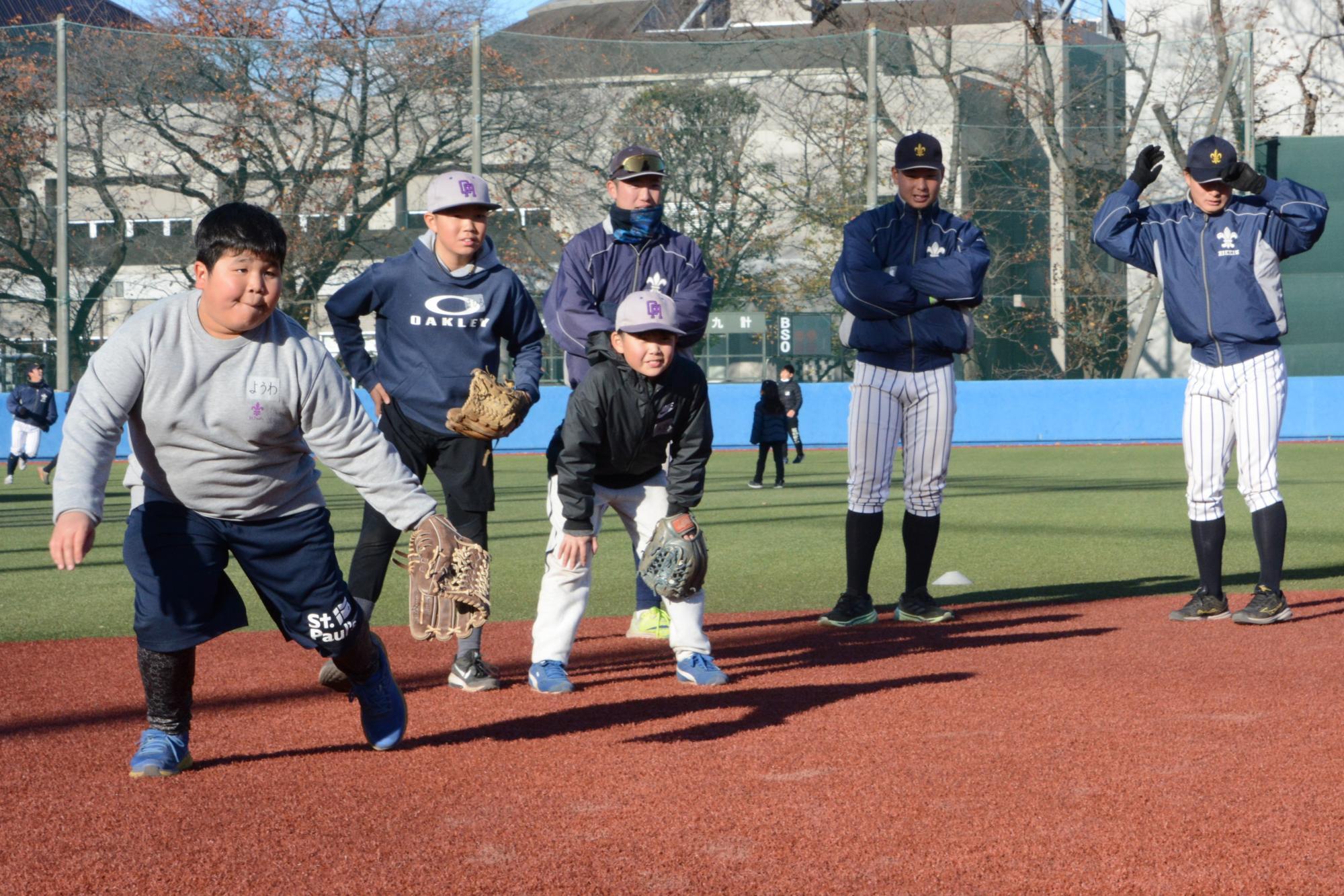 立教大学野球部グラウンドでノックを受ける子どもたち