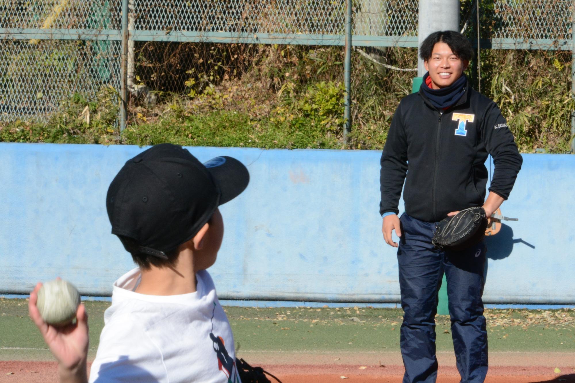 東大球場で地域の子どもとキャッチボールする杉浦海斗主将