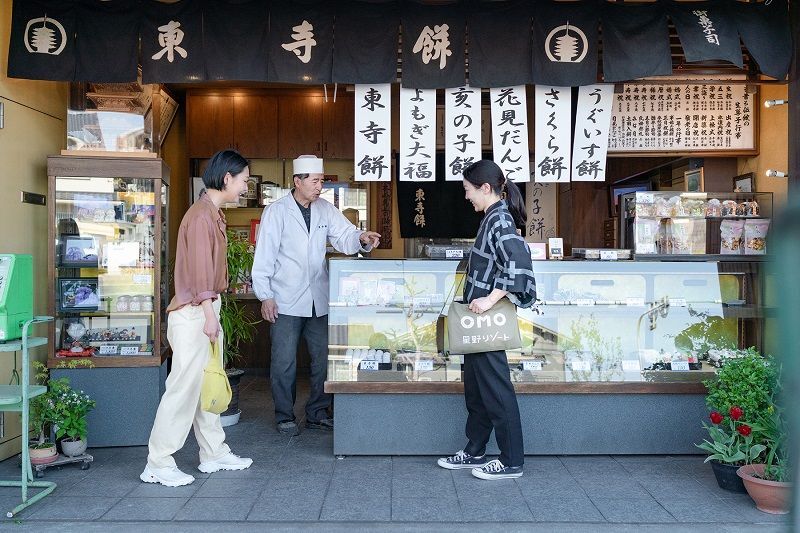「OMO3京都東寺」の周辺にある、創業100年を超える和菓子店「東寺餅」。ご近所ガイド OMOレンジャーとのほほえましいやりとり(画像提供/星野リゾート)