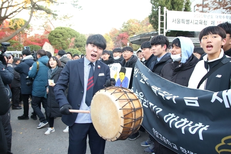 韓国版「センター試験」の当日の開場前の様子。高校の後輩が受験生を応援するほどに熾烈。筆者撮影。昨年秋、ソウル市内にて