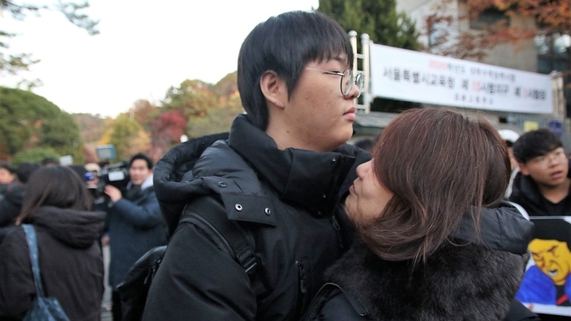 大学受験当日、会場に入る直前に子と抱擁する韓国のママ。筆者撮影。昨年秋、ソウルにて