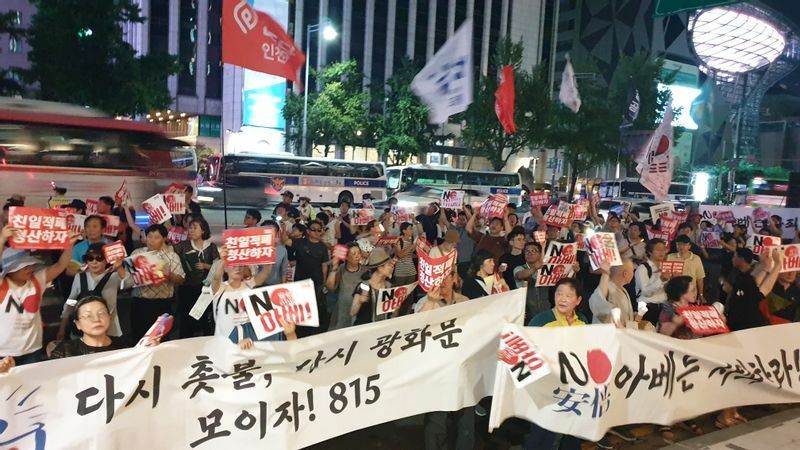 2019年のNO JAPANデモの最終地点、朝鮮日報前にて。右下に青文字で「安倍」。白のプラカードにもハングルで「アベ」と。筆者撮影
