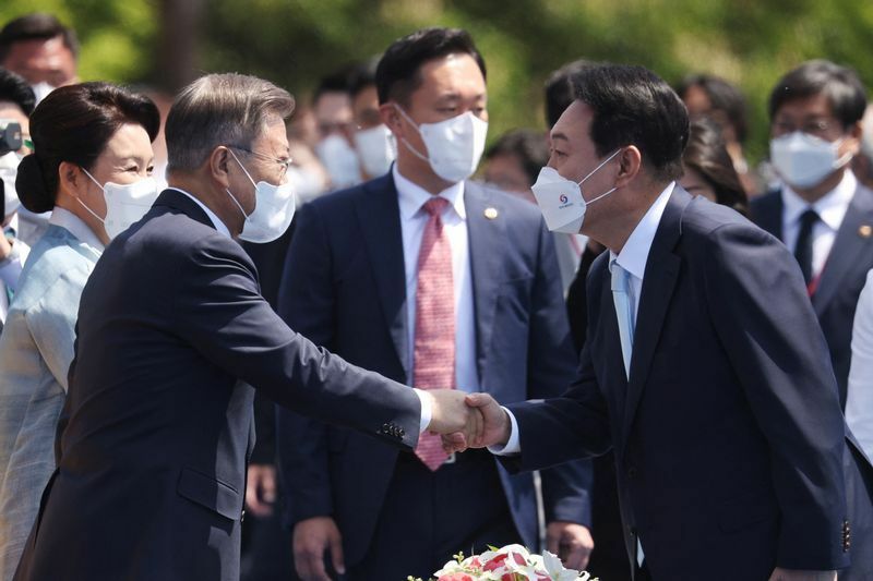 就任式で文在寅前大統領と握手する尹新大統領