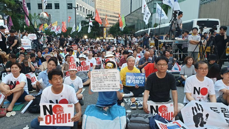 2019年のNO JAPANデモの様子。先頭の男性などが「NO安倍」のカードを掲げている