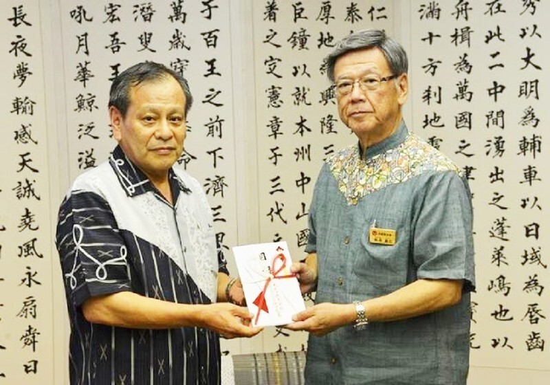 県民会議への寄付金贈呈式。左はオキコ(株)代表取締役社長仲田龍男氏(沖縄県提供)