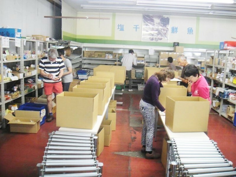 元食料品店の倉庫で食料の箱詰めをするボランティアの人たち（フードバンク山梨提供）