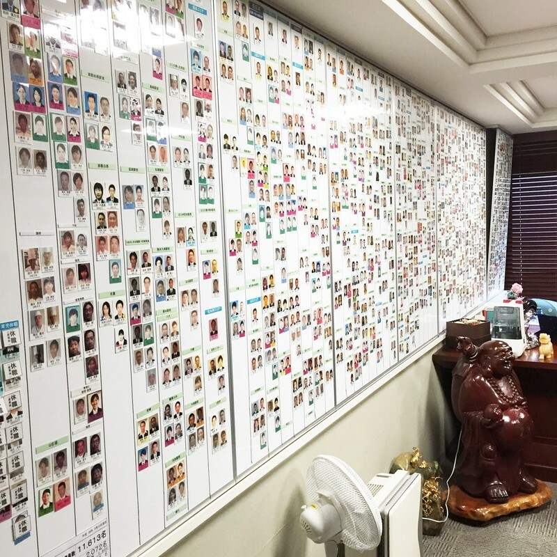 会長の執務室には、壁面いっぱいに従業員たちの顔写真が並ぶ