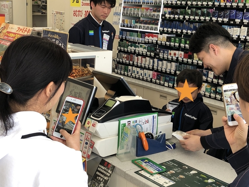わが子のレジ打ち体験を記念撮影するおかあさん(筆者撮影)